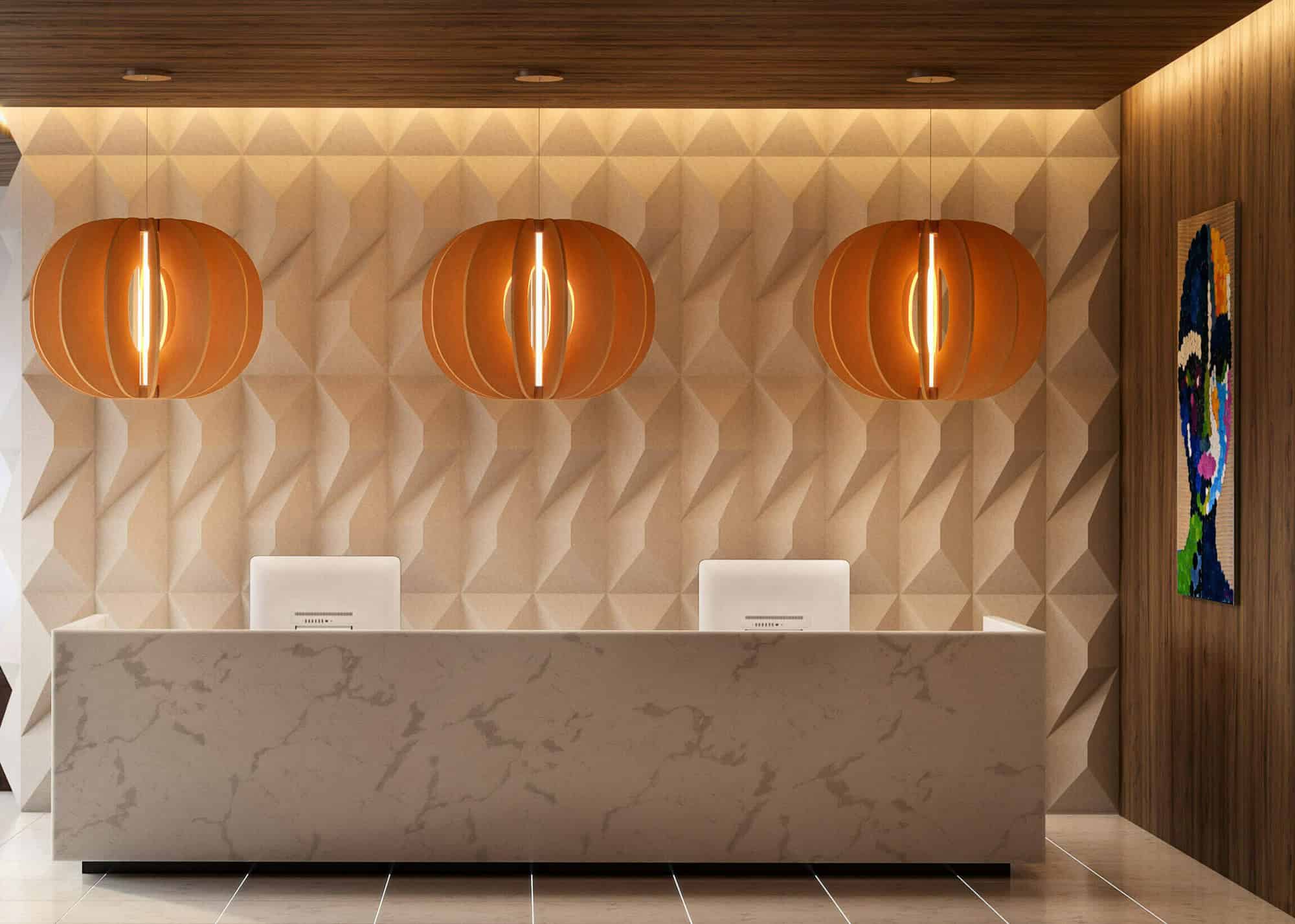 Reception area featuring a marble desk with two computers in front of a textured accent wall. Three round, contemporary light fixtures hang from the ceiling.